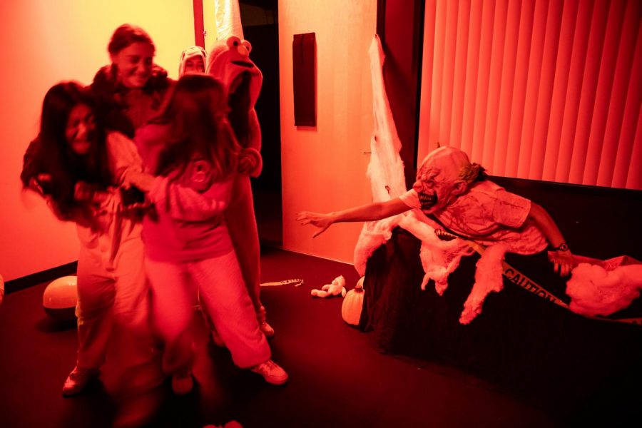 A sophomore with a clown mask scares a group of students during the annual Haunted House.