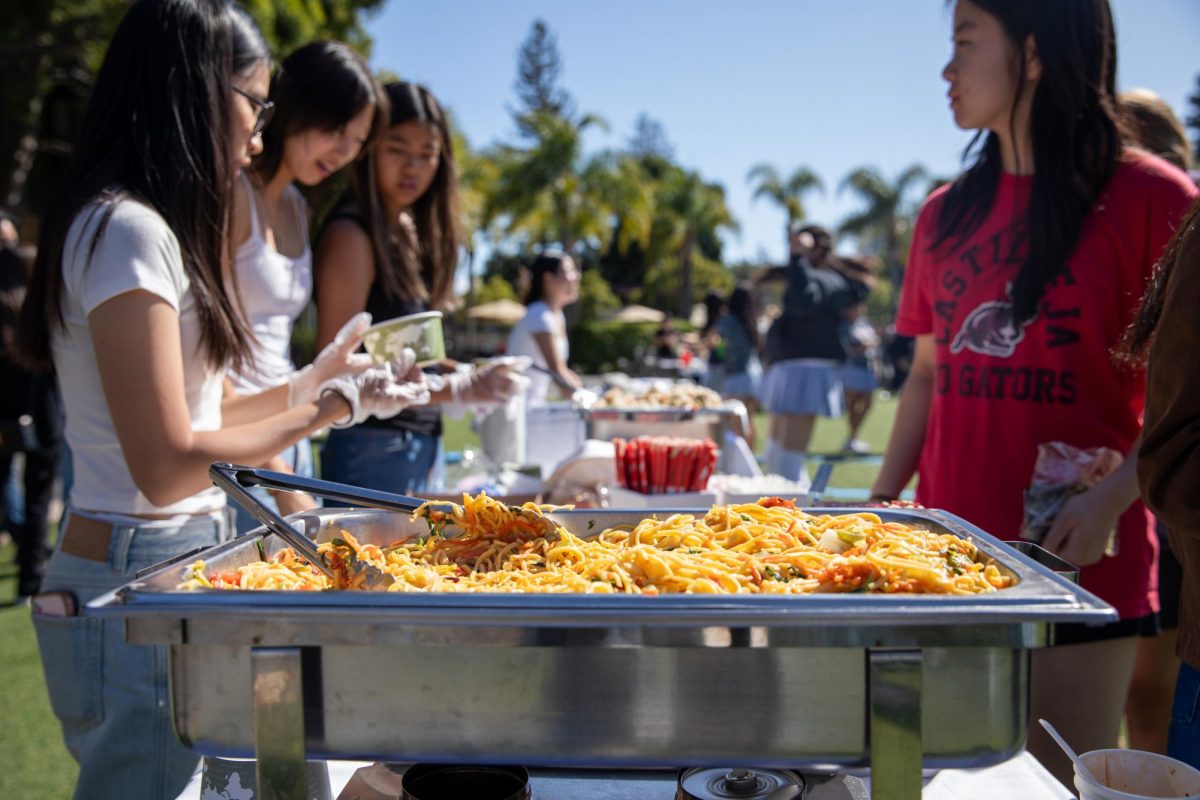TAG student leaders serve fresh noodles at a food stall.